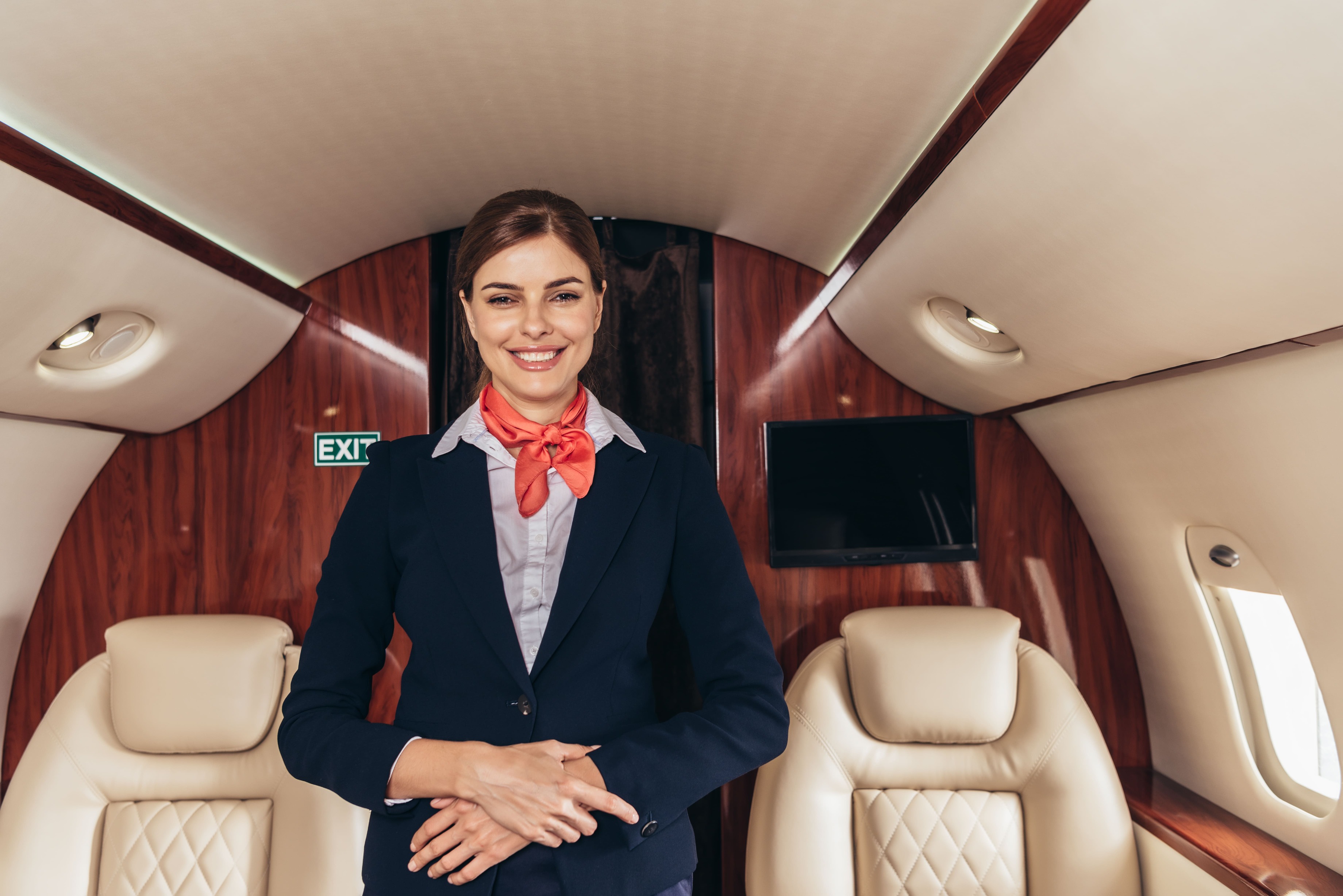 A woman in business attire stands confidently in the cockpit of a private jet, showcasing a professional aviation environment.