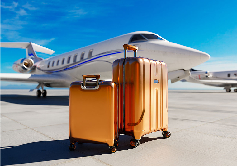 A white airplane behind a pair of suitcases against a clear blue sky.