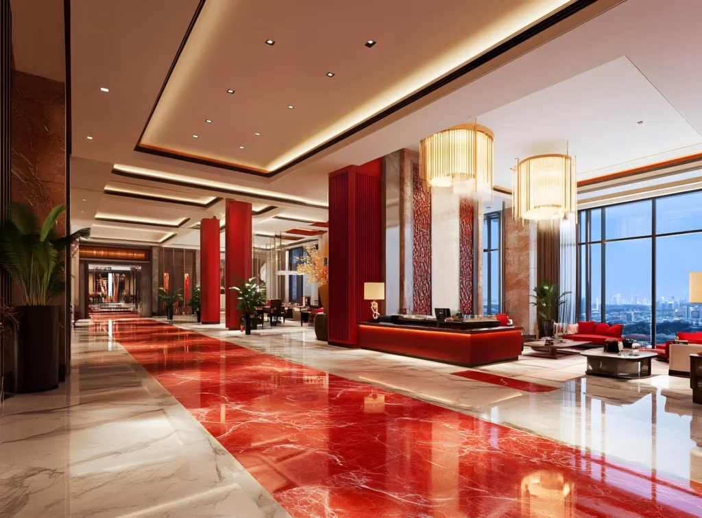 Luxurious hotel lobby with red and white marble floors, gold chandeliers, red columns, and large windows.